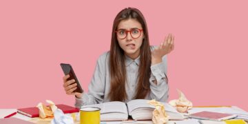 Stressful woman bites lower lip, raises hand, types text message on cell phone, tries to find unknow