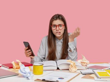 Stressful woman bites lower lip, raises hand, types text message on cell phone, tries to find unknow