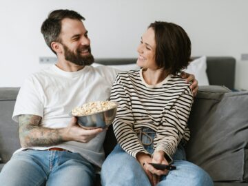 Happy young white couple watching TV