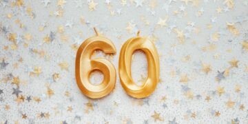 Number 60 sixty golden celebration birthday candle on Festive Background.