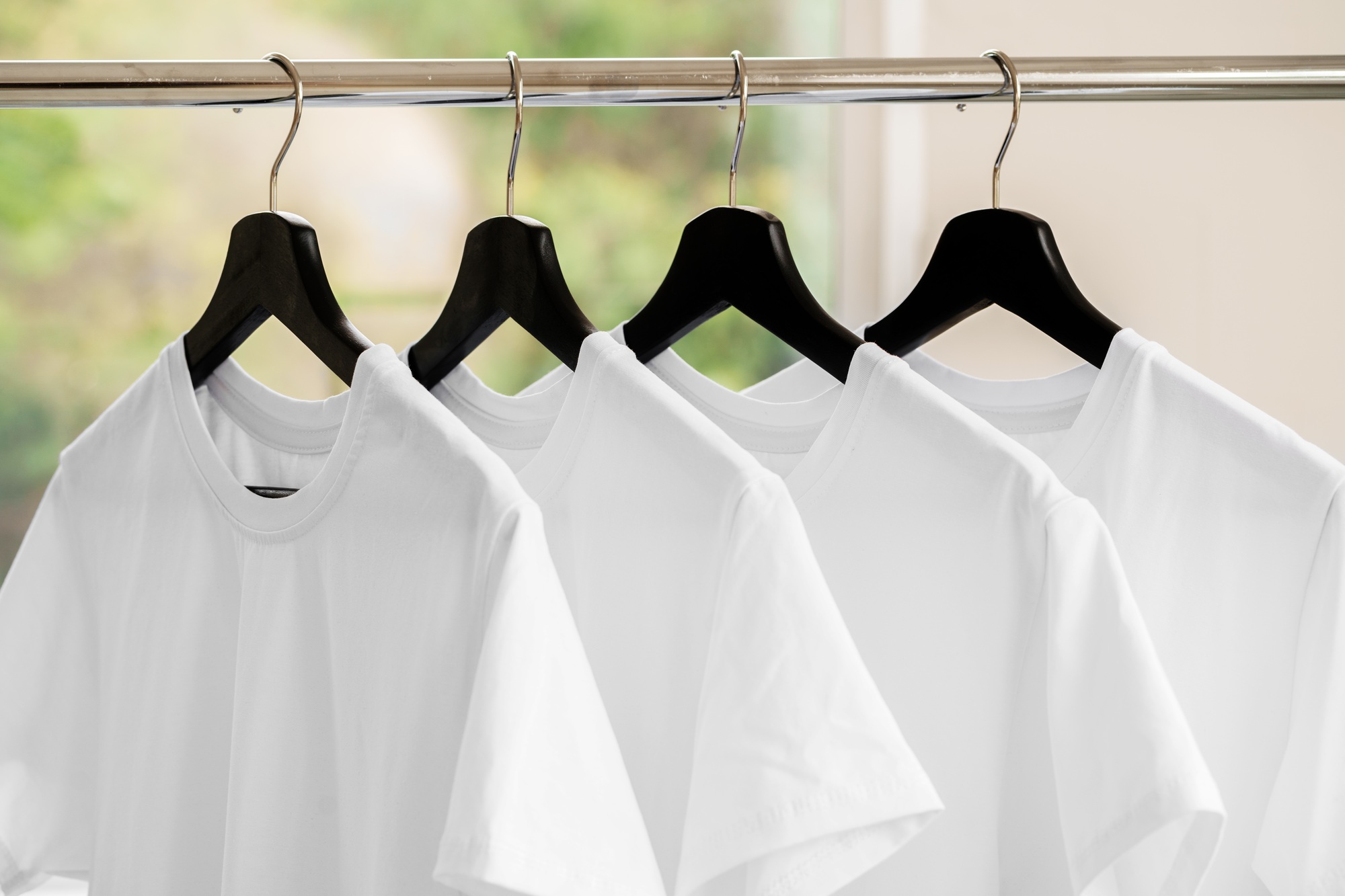 Row of white t-shirts on hangers on rack